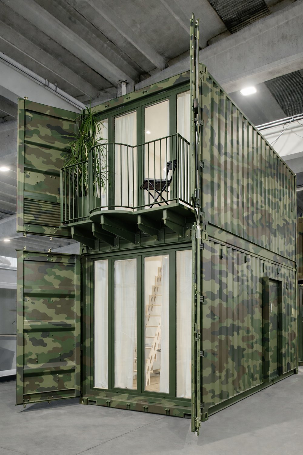 Der zweistöckige Container in der Werkstatt in militärischer Tarnlackierung